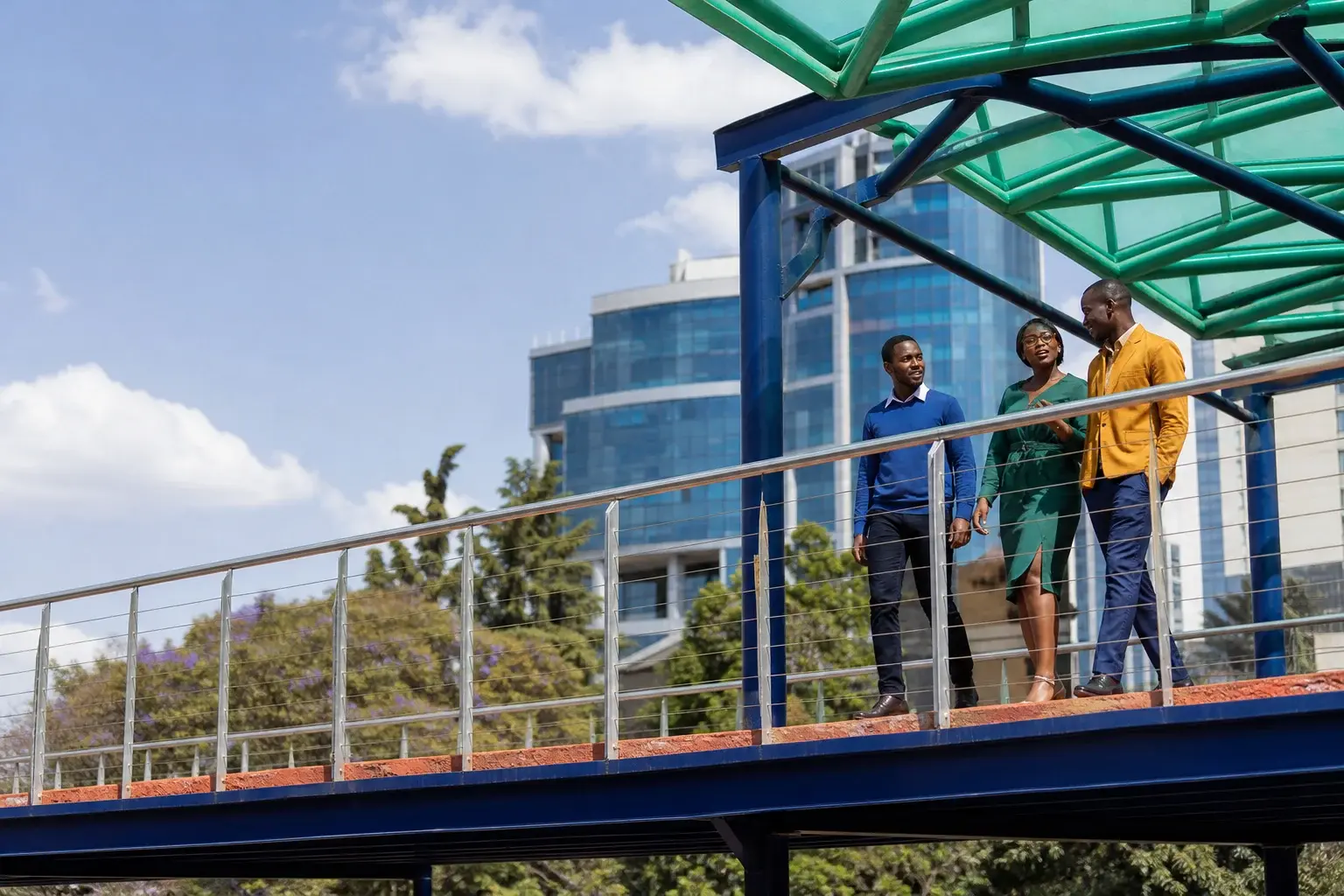 Professionals walking across a Nairobi pedestrian bridge
